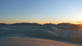 <b>White Sands Sunset - </b>The sun dips behind the mountains and the glow of the sunset turns them orange. (04/19/09) White Sands Sunset