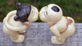 <b>Posed - </b>One of our managers just returned from a trip to China and brought Donna back a small gift of these little dolls that are posed as if kissing. He went on to explain that the dolls are left in a very prominent place in the home. They normally are left in the kissing pose unless one partner is upset with the other. Then that person's doll is faced away from the other. This is a gentle way of letting the other partner apologize for whatever misdeed they have committed. Sounds quaint, but a quick search of the Internet turns up no evidence of this fable or these dolls. I wonder if I should bust them open and see what kind of contraband he smuggled into this country... (03/23/2005) Posed