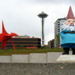 <b>Gnorm, an Eagle and the Space Gneedle - </b> The red object in the background is Alexander Calder's Eagle sculpture completed in 1971 and weighs 6 tons. The tall pointy thing is the Space Gneedle and was built for the 1962 World's Fair and weighs 9,550 tons. It is impolite to ask a gnome his age or weight.... (05/27/07) Gnorm-an-Eagle-and-the-Space-Gneedle