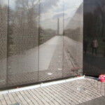 <b>Vietnam War Memorial II - </b>The granite is from India and was chosen for its reflective properties. Here you can see the Washington Monument's reflection along with the photographer's, his wife and her friend. (04/10/2007) Vietnam War Memorial II
