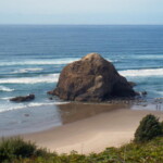 <b>Other Rocks 3 - </b>The waves give some sense of scale, but a better judge is to gage the rocks against the height of the two people walking along the beach. (10/02/06) Other Rocks 3