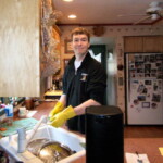 <b>Househusband Jim - </b>Cousin Mary's husband Jim does a little cleaning up while everyone else is sitting around the table chatting. Jim works for the New York Stock Exchange and used to work as a trader on the floor, but now he has a less noisy job in a back room deciding the fates of Fortune 500 companies. (04/13/2007) Househusband Jim