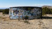 <b>Colorful Cistern - </b>The barbed wire fence was little deterrent as this water tank along NM14 got a very colorful paint job. There was a geocache just a little further north along the fence. (04/16/09) Colorful Cistern