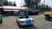 <em>Tenmile</em> - An interesting building with a Studebaker front end perched on the roof. We had a nice little chat with the fellow in the yellow pick-up about car color and parking lots. (10/04/21)